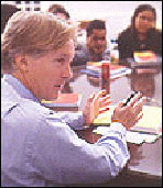 Teacher sitting and discussing with students